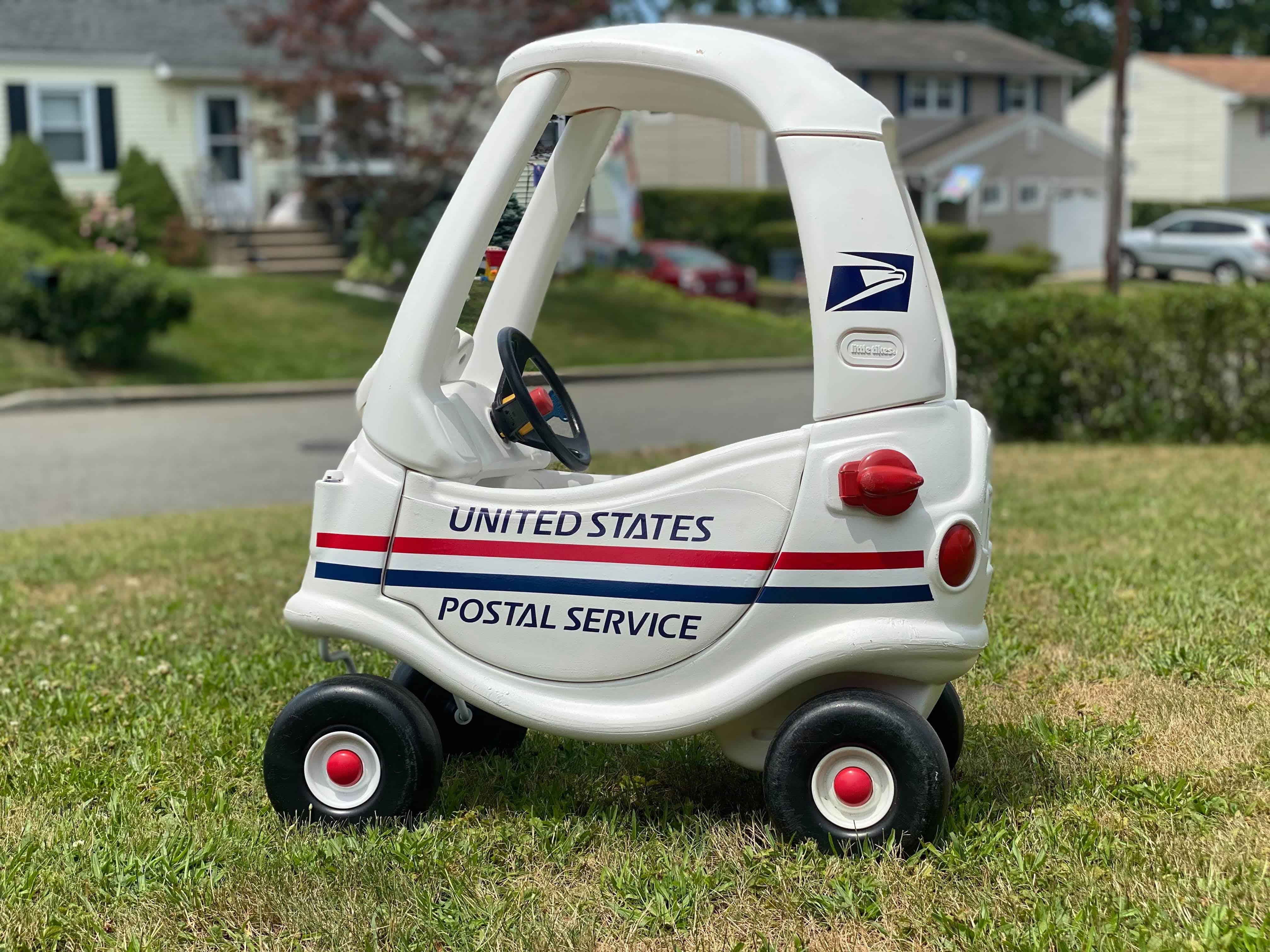 image shows a spray painted cozy coupe plastic car made to look like a postal truck