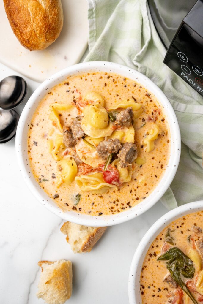 image shows two bowls of tortellini soup