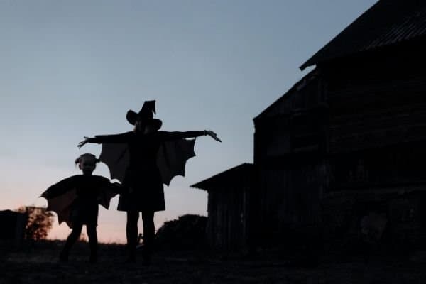 woman and child in Halloween costumes at dusk