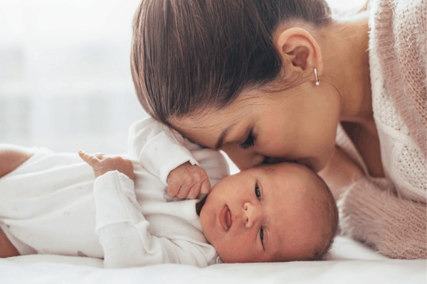 new mom kissing newborn baby