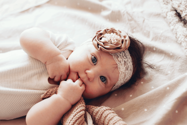 image shows a  little girl laying on her back