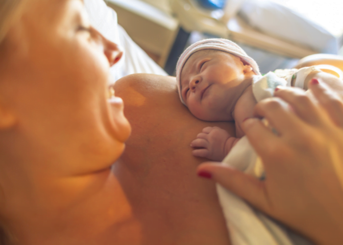 image shows woman holding newborn baby