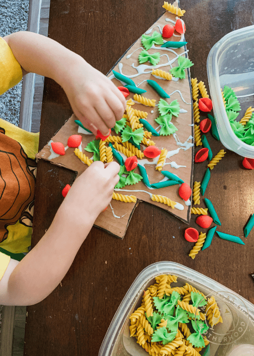 image shows a child gluing pasta to cardboard