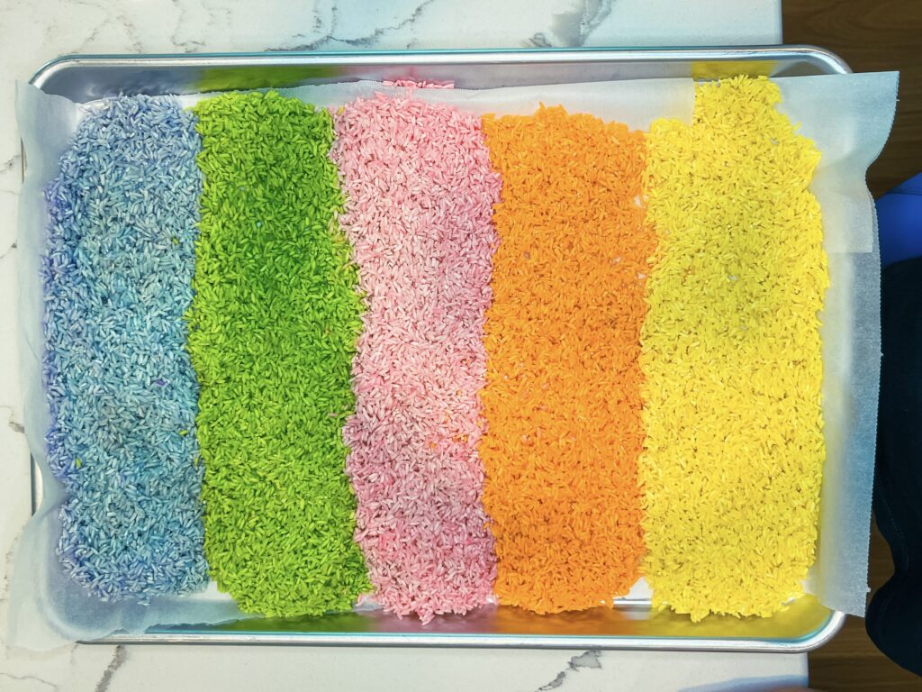 tray of rainbow rice for sensory bins