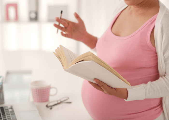 image shows a pregnant belly and notebook