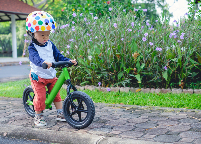 image shows a toddler on a balance bike