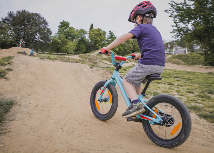 image shows a child riding a bike