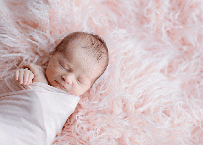 image shows a sleeping pink baby
