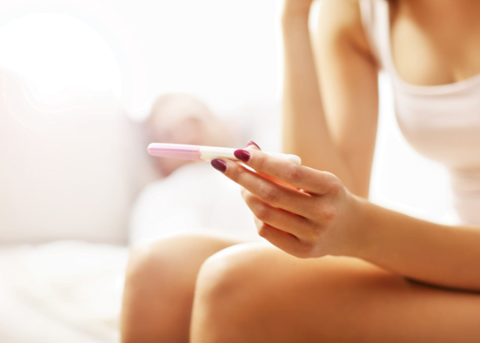 image shows a person holding a pregnancy test