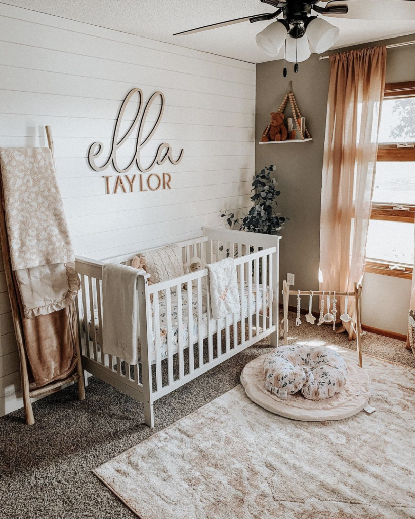 Wood accent wall in baby girl nursery