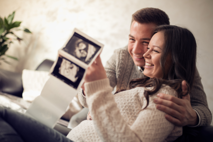 couple holding ultrasound pictures
