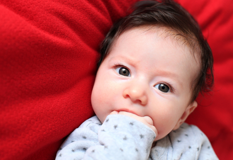 baby chewing on hand