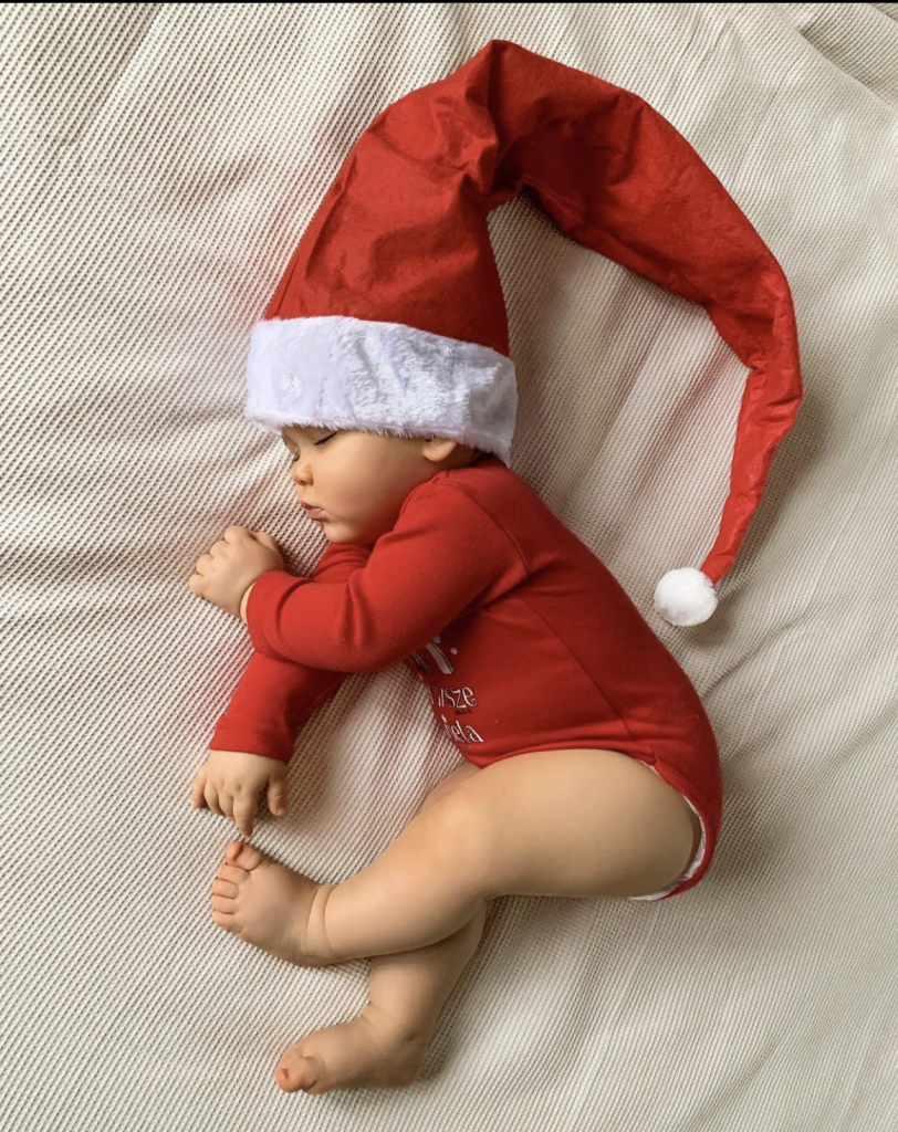 sleeping baby wearing Santa hat