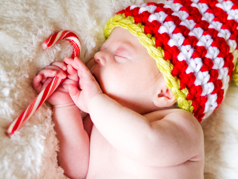 sleeping baby holding candy cane