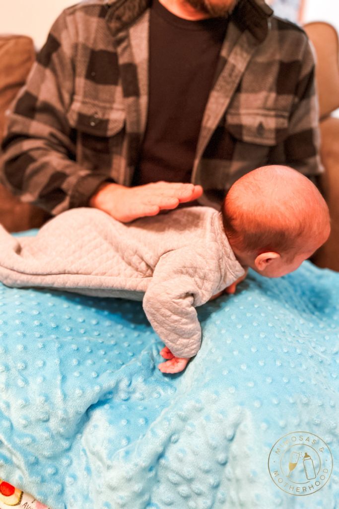 burping baby laying on lap