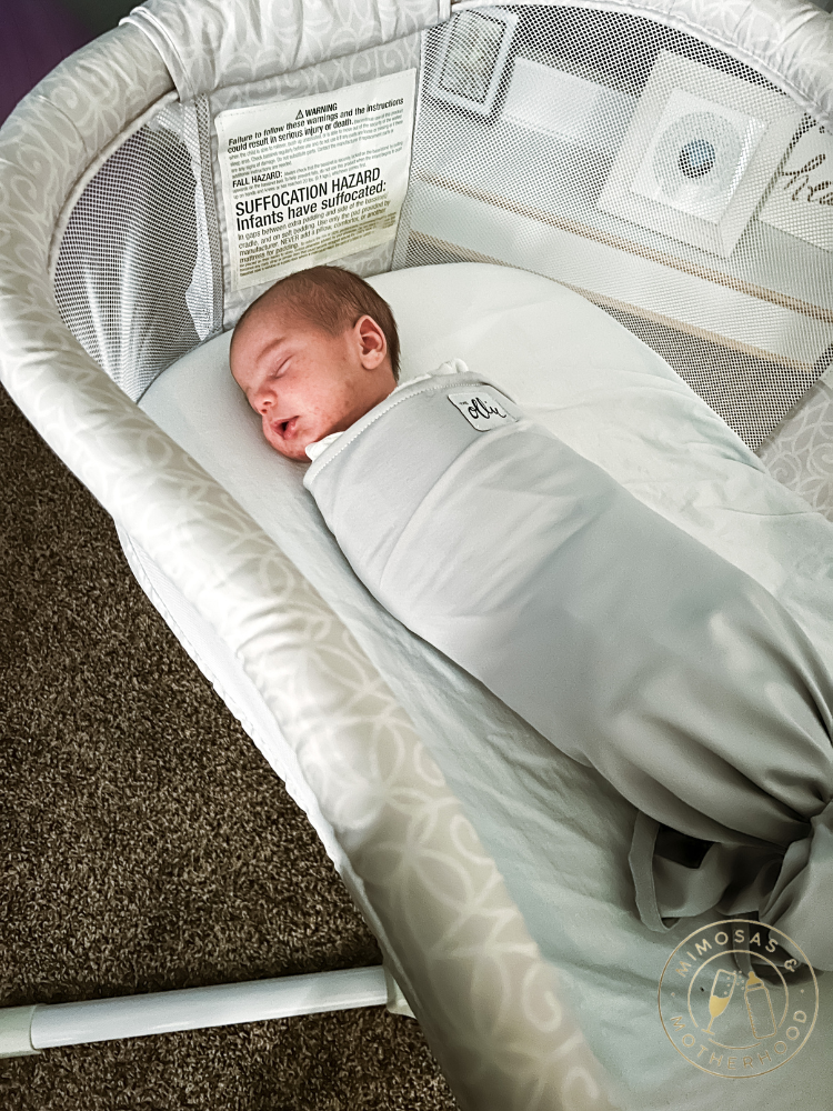 baby in ollie swaddle sleeping in a bassinet