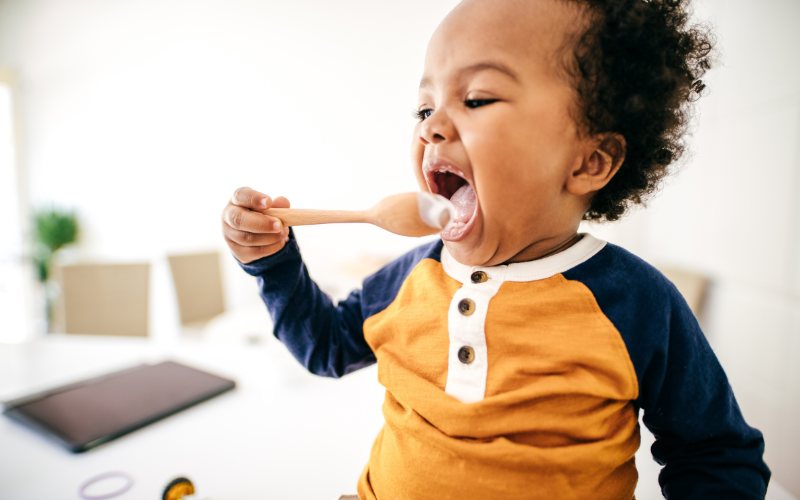 child eating food off spoon