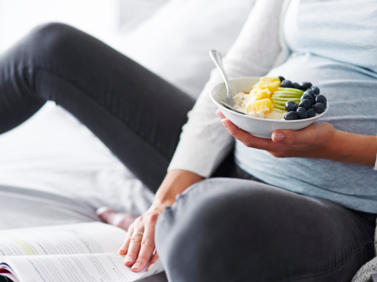 pregnant woman holding breakfast