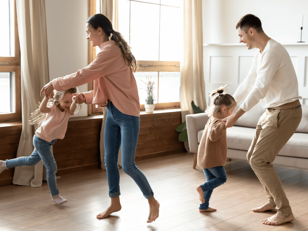 image shows two parents swinging two kids