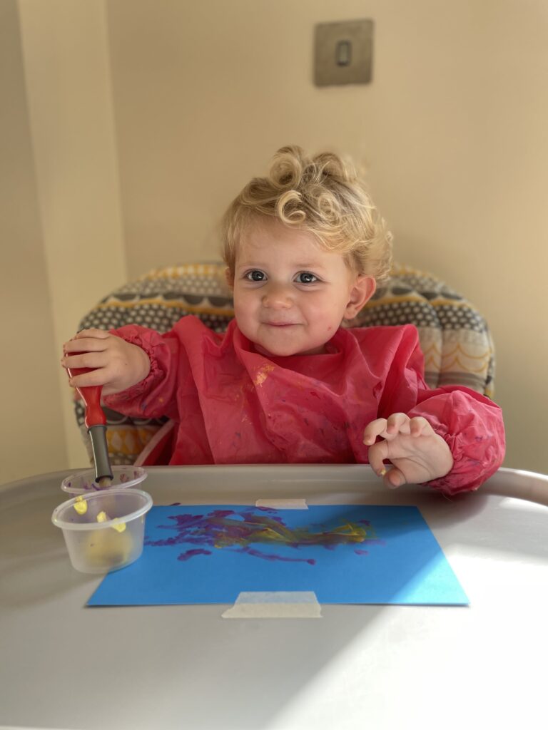 image shows a child playing with art materials