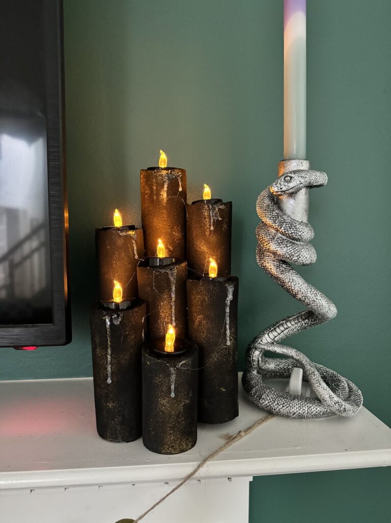 image shows DIY pool noodle halloween candles on a mantel