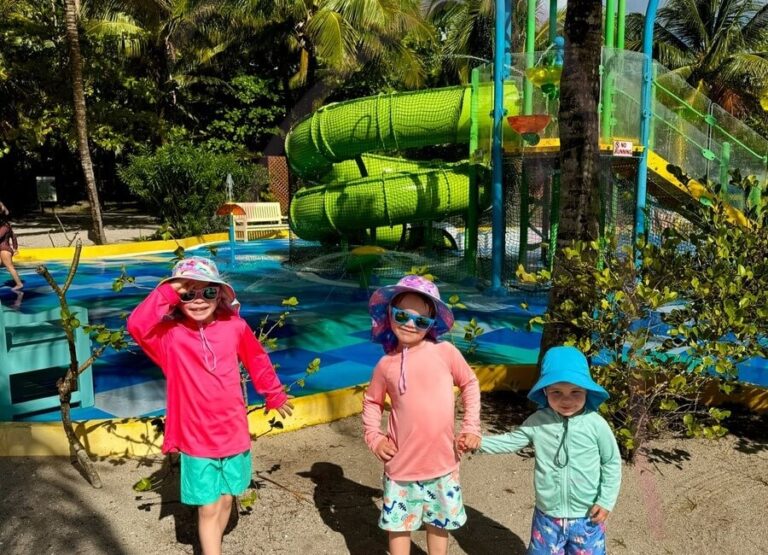 children stand in front of the water slides on harvest caye belize