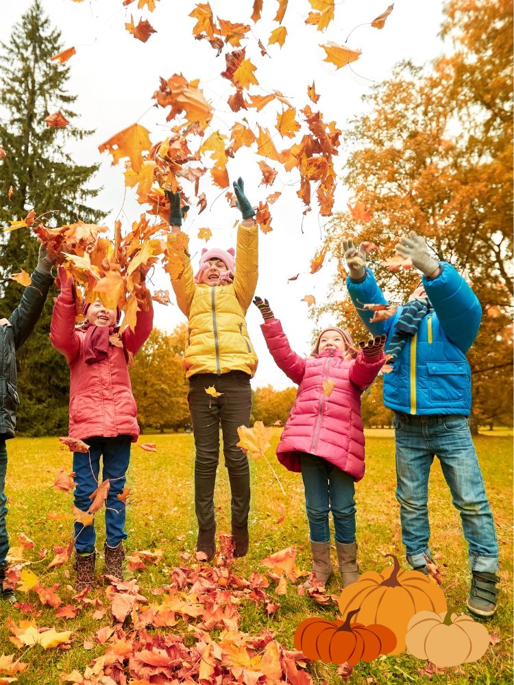 image shows children tossing leaves in the air