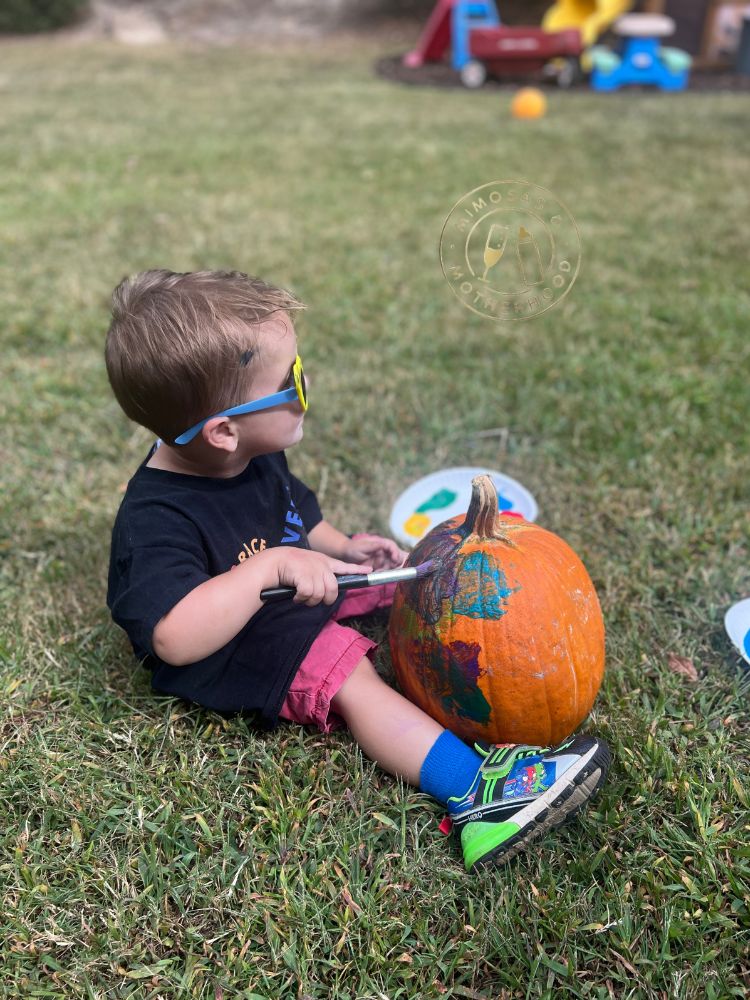 image shows a child painting pumpkins