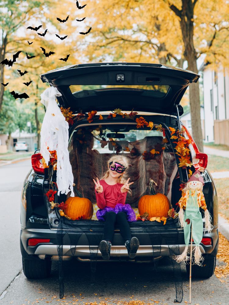image shows a child in the back of a trunk or treat vehicle