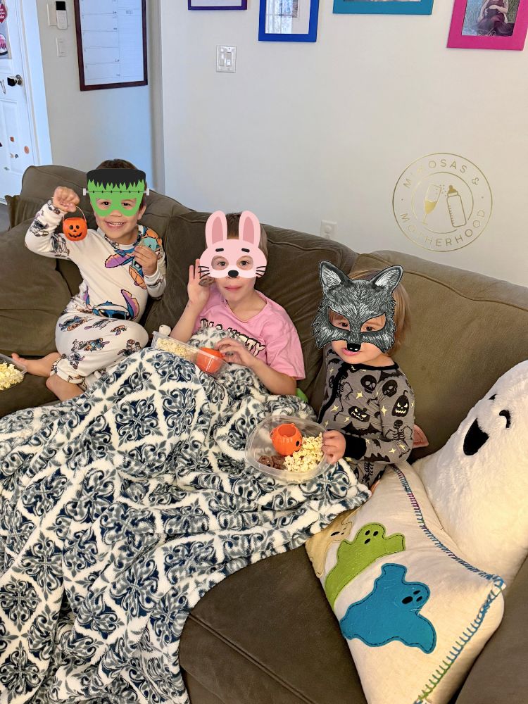 image shows children with Halloween candy watching a Halloween movie
