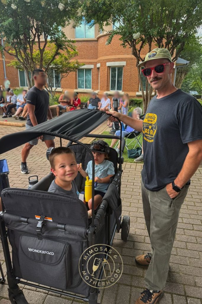 image shows a man with two children in the Wonderfold wagon