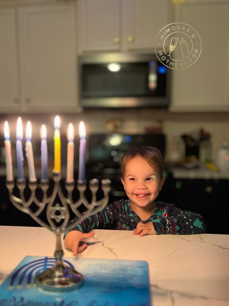child with a lit menorah during Hanukkah