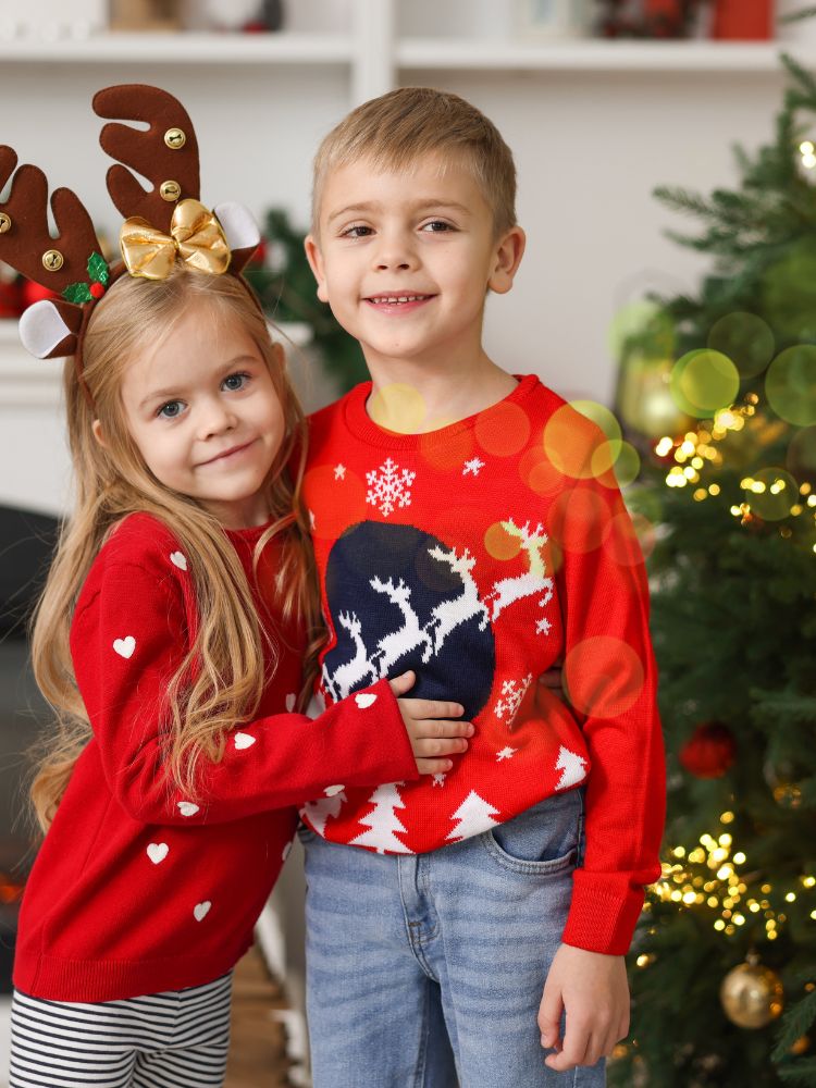 kids hugging in front of Christmas tree