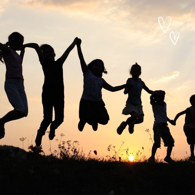 children jumping at sunset