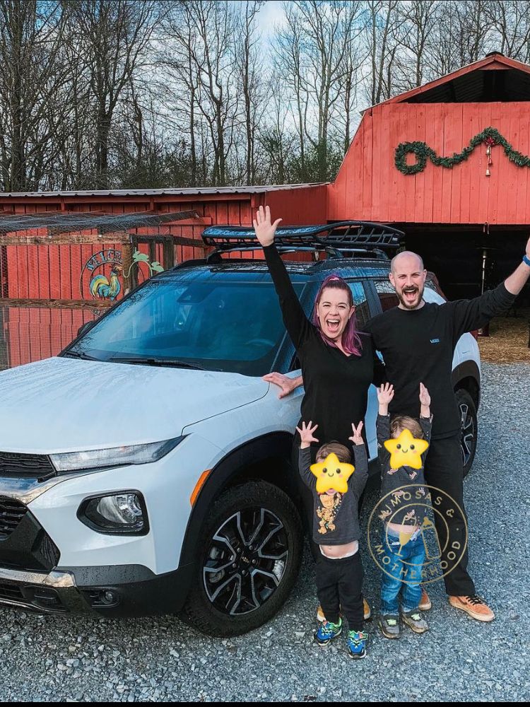 family on a road trip in front of car