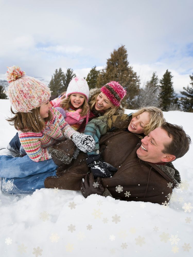 family playing outside in the snow