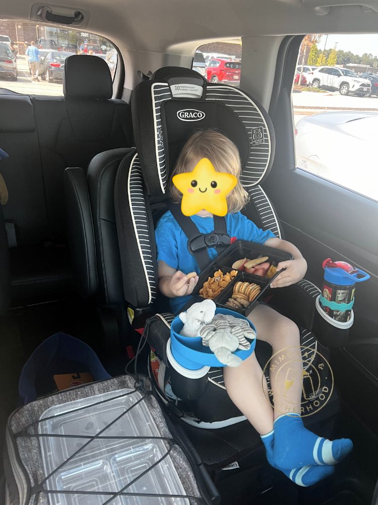 child using a snack tray in car