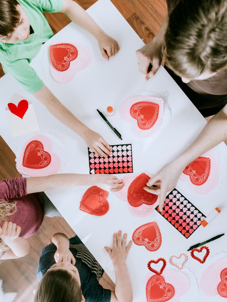 image shows a family making valentines around a table