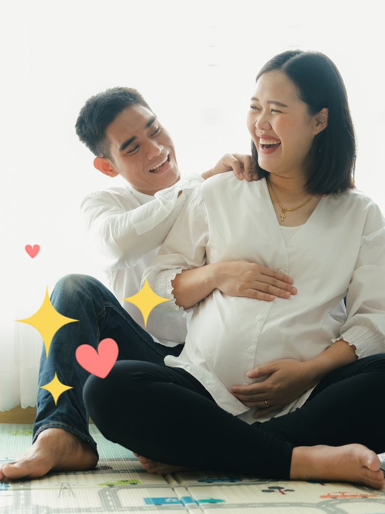image shows a pregnant woman and man sitting on the ground
