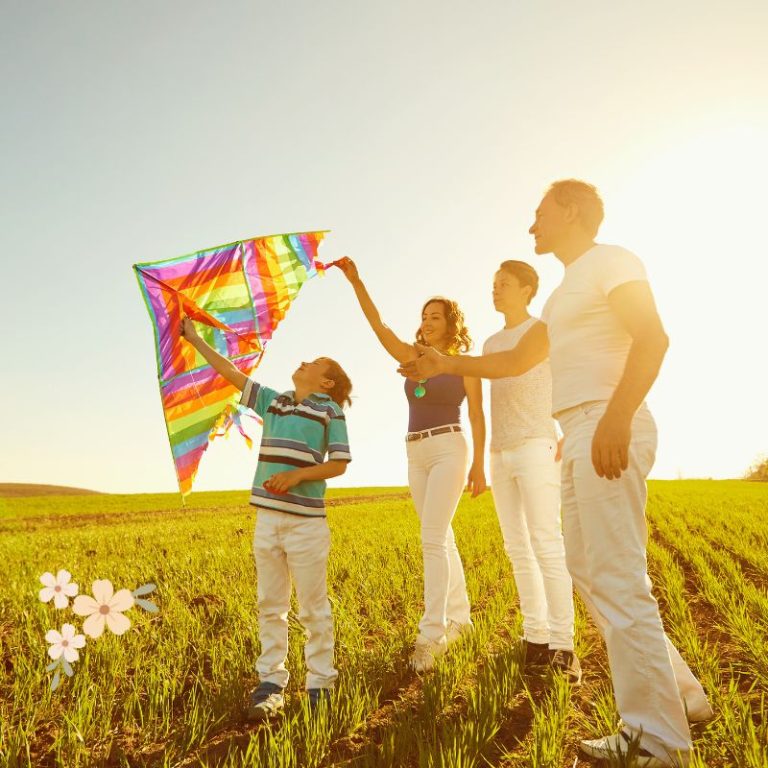 family flying a kite outside in a field