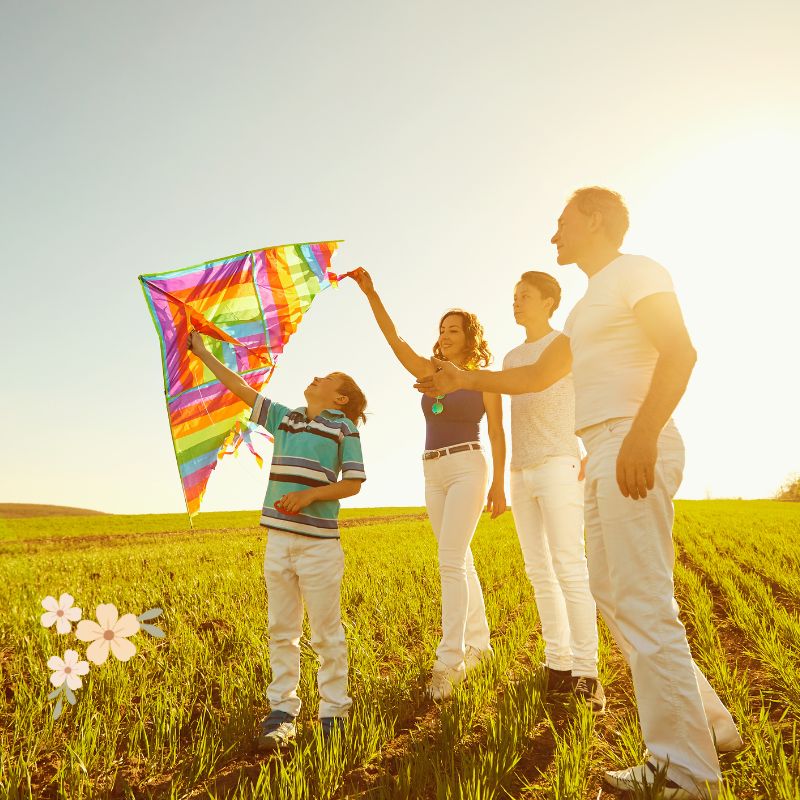 family flying a kite outside in a field