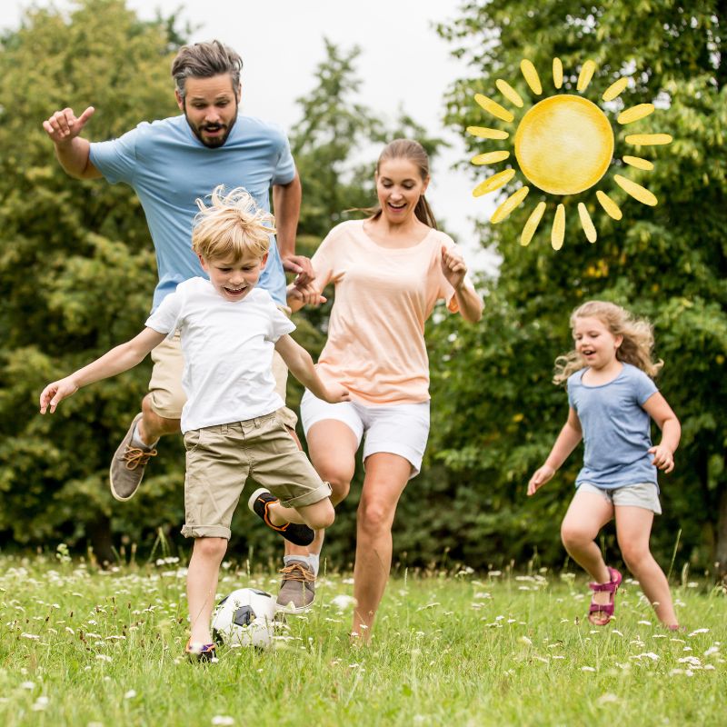 image shows a family playing soccer outside in the summer